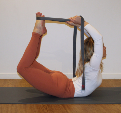 een yogalerares voert een oefening uit met een yogariem